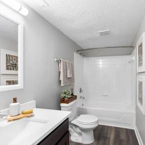 A white bathroom with a toilet, sink, and mirror.