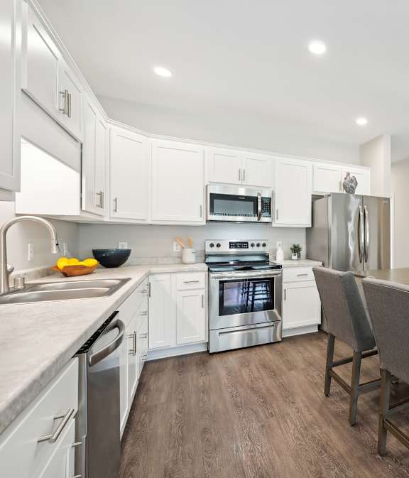 A modern kitchen with white cabinets and stainless steel appliances.