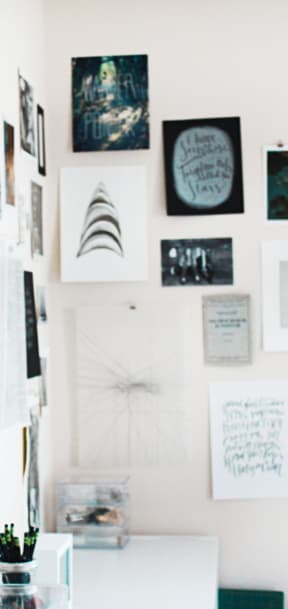 a wall of art in a home office