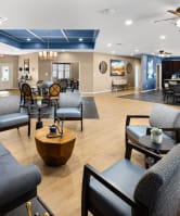a large living room with couches and chairs and a dining room with a bar