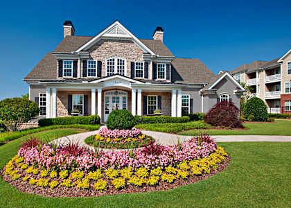 A large house with a flower bed in front.