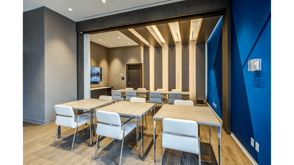 a dining room with wooden tables and chairs and a blue wall