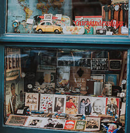 A vintage store window that has old collectables displayed.