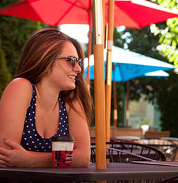 A couple chatting over a cup of coffee outside on a patio.