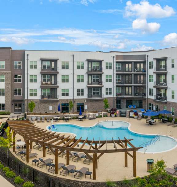A large apartment complex with a pool and a deck.