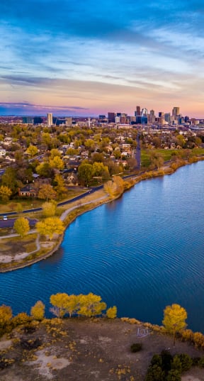 an aerial view of a lake with a city skyline in the background