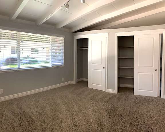 a bedroom with a closet and a large window