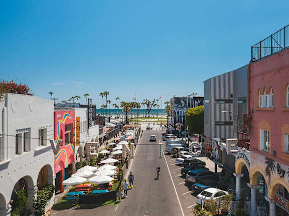 A street view of a row of buildings with a clear blue sky above.