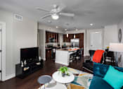 Thumbnail 11 of 27 - a living room area with tv and kitchen in background