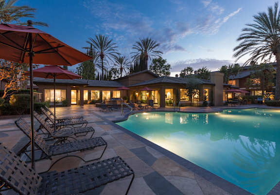 a resort style swimming pool with lounge chairs and umbrellas at St. Moritz Apartments,California