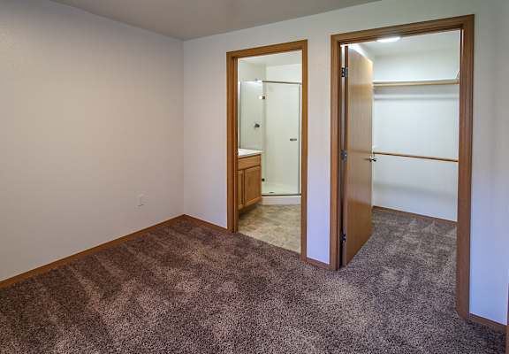 A room with a carpeted floor and a doorway leading to another room.