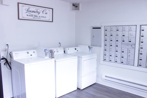 a laundry room with four washer and dryer machines