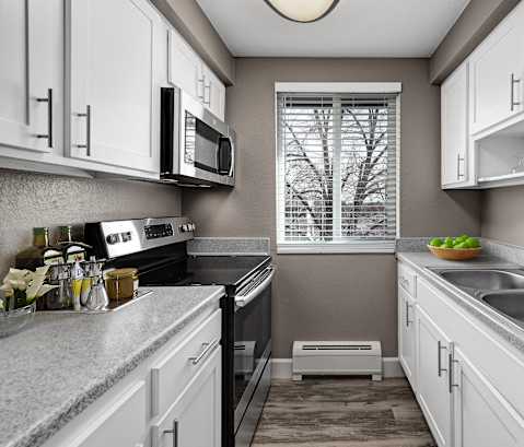 a kitchen with white cabinets and a sink and a window