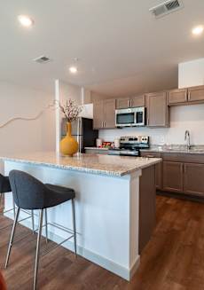 a kitchen with an island with two stools in front of it