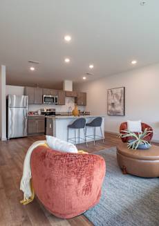 a living room with a couch and a chair and a kitchen