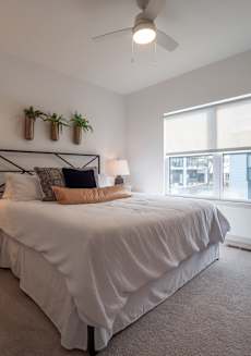a bedroom with a large white bed and a window