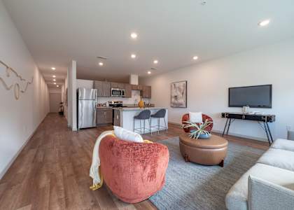 a living room with a couch and a chair and a kitchen