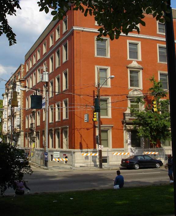 a building on the corner of a street with cars parked in front of it