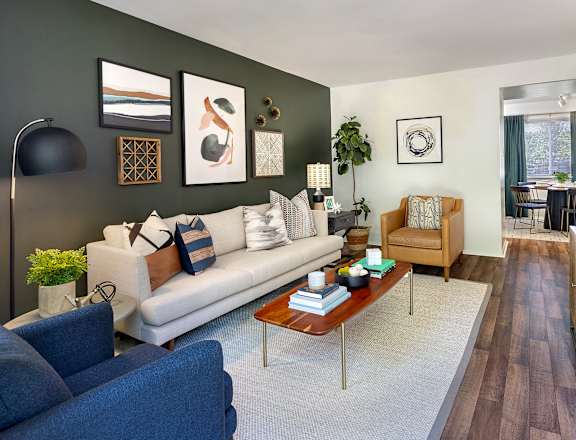 A living room with a white couch and a blue chair.