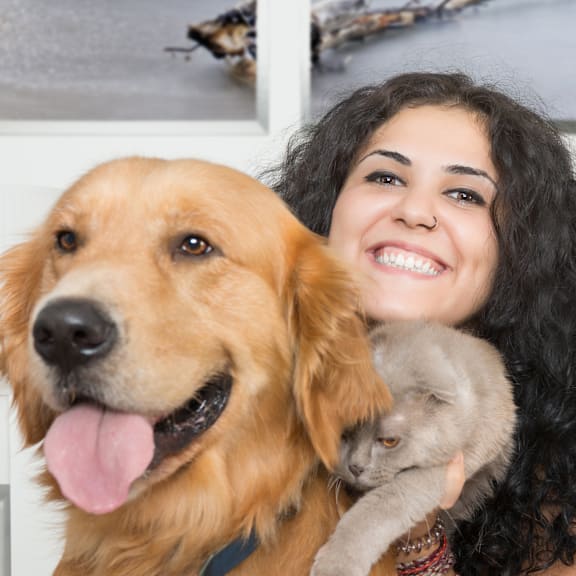 A woman is holding a cat and a dog.