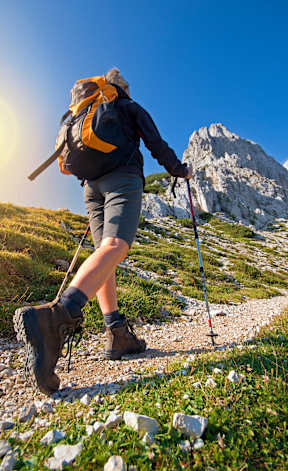 a woman hiking in the mountains with trekking poles