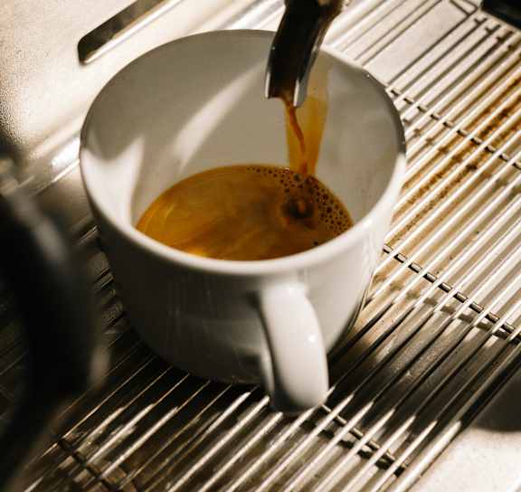 Coffee being poured into a white cup.