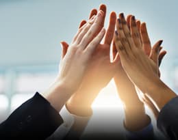 a group of people high-fiving their hands together representing Integrity and Respect