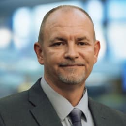 a man wearing a suit and a blue shirt