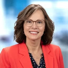 a woman wearing glasses and a red jacket