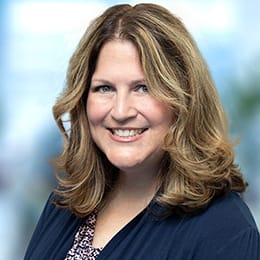 a woman with long hair smiling at the camera