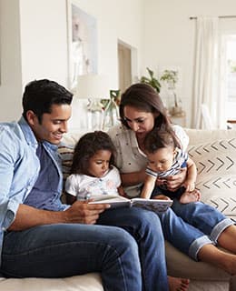 Family sitting on the couch with a book at Alhambra Cove, Miami Florida