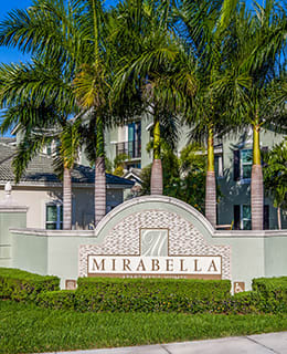 a house with palm trees and a sign in front of it at Mirabella Apartments, Princeton, FL