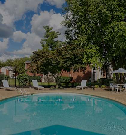 Swimming pool with lounge seating - East Chase Apartments