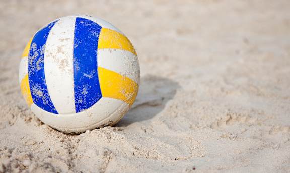 A blue and white striped beach ball sits on the sand at Arbours at Ensley Apartments, Pensacola, FL 32514