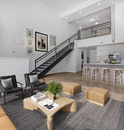 A living room with a staircase leading to the kitchen.