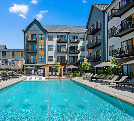 a swimming pool with an apartment building in the background