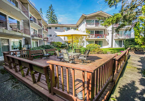 a wooden deck with a table and chairs and an umbrella