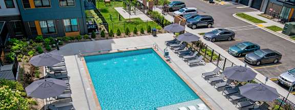a swimming pool with chairs and umbrellas at a hotel