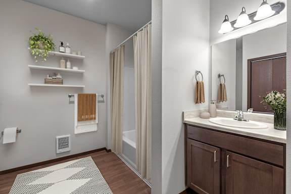 A bathroom with a sink, mirror, and a shower.