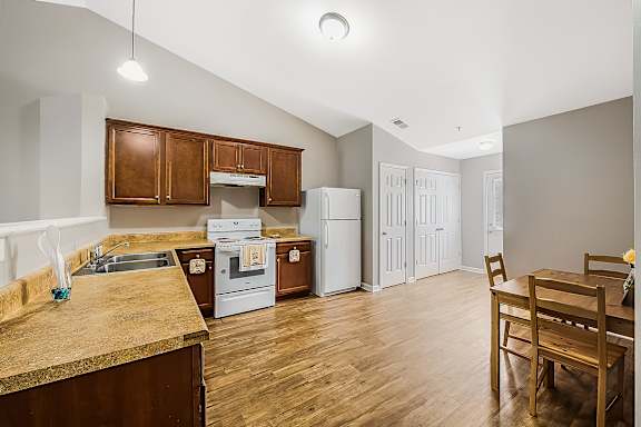 A kitchen with wooden cabinets and a white fridge.