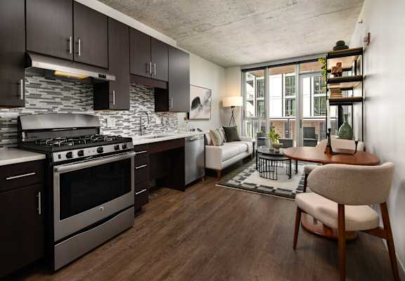 A modern kitchen with dark wood cabinets and a stainless steel stove.