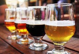 a row of beer glasses sitting on a wooden table
