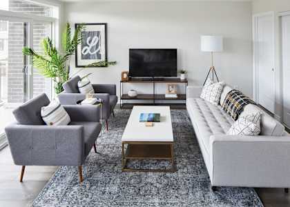 a living room with couches chairs and a coffee table and a television