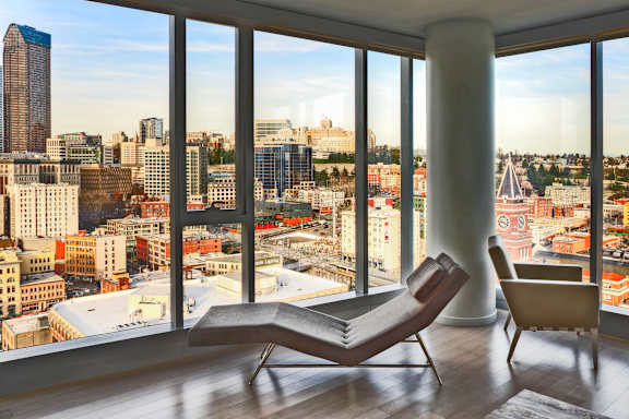 a living room with a chair and a view of the city