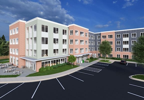 A large multi-story building with a parking lot in front.