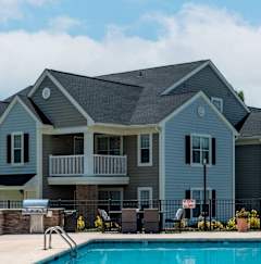 A large house with a pool in front.