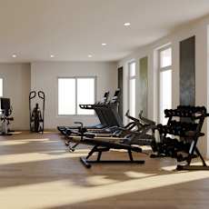 A gym with a variety of exercise equipment including treadmills, stationary bikes, and rowing machines.