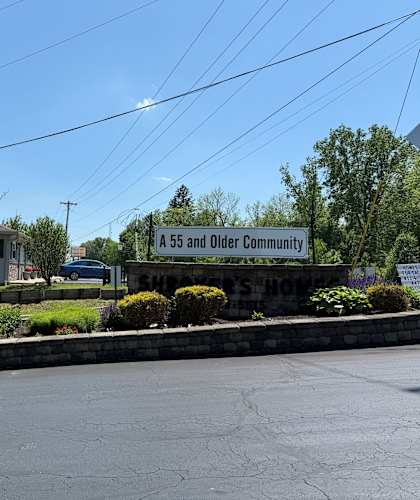 A residential street with a sign reading "A 55 and Older Community".