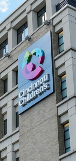 A sign for Cincinnati Children's hangs on a building.