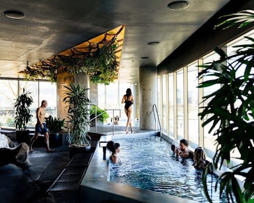 A group of people are enjoying a hot tub in a spa-like setting.